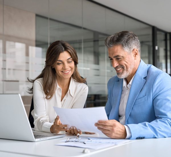 Two colleagues reviewing documents together in office at Pioneer Business Brokers.